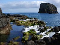 Meerwasser schwappt über bemooste Felsen bei Porto da Cruz